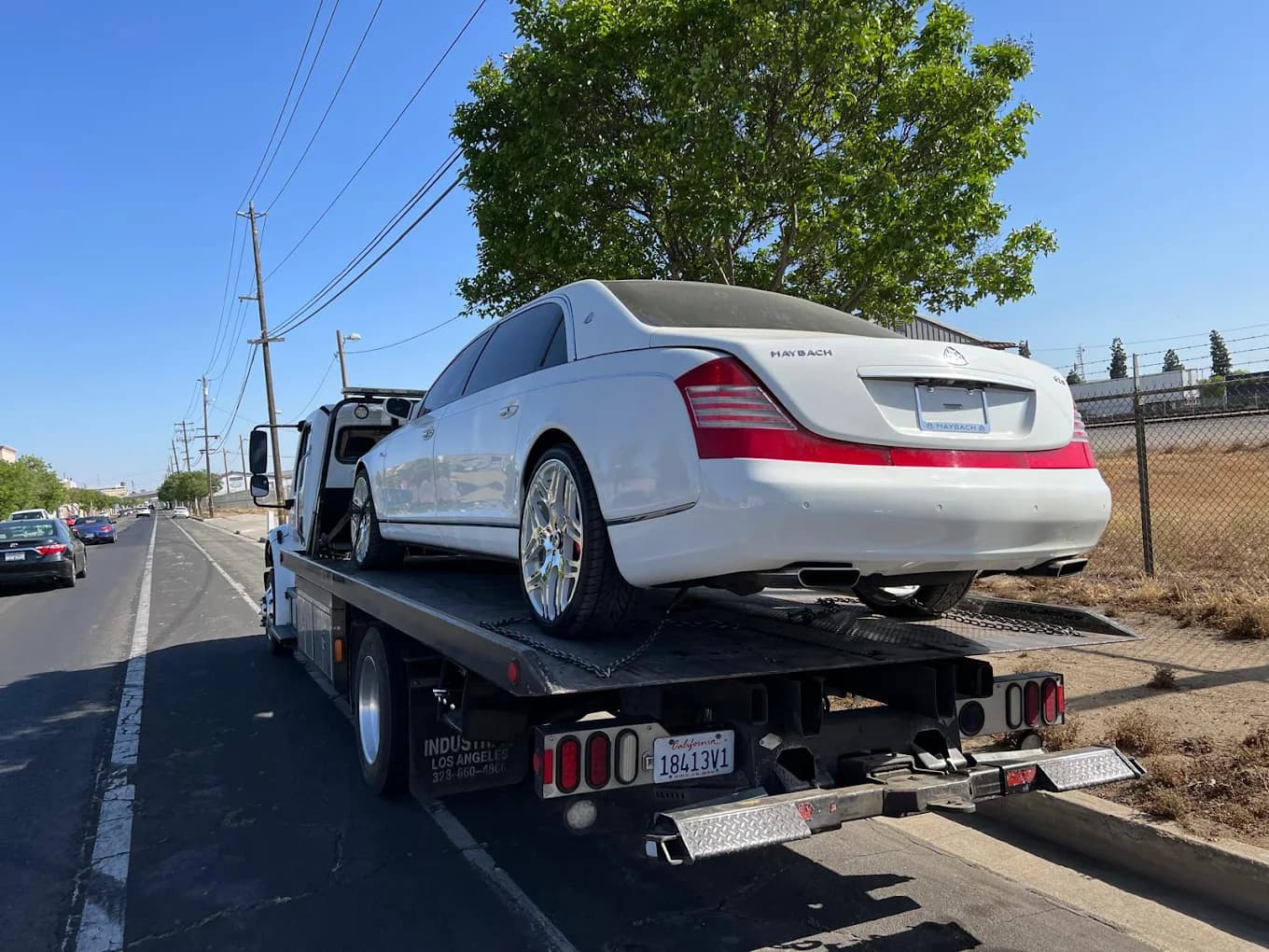 White luxury sedan secured on a flatbed tow truck