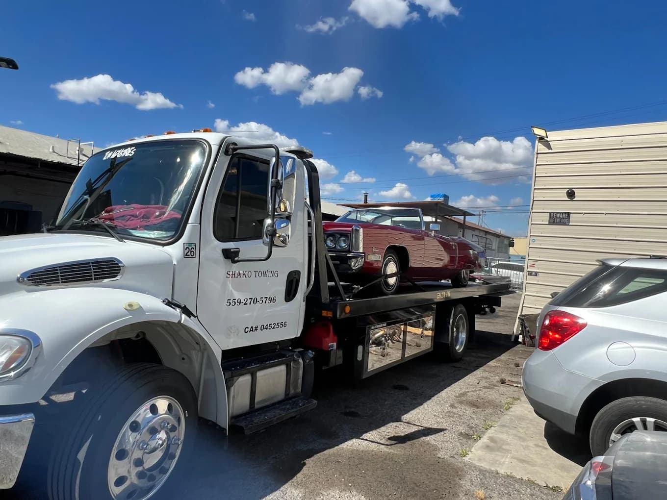 Shako Towing truck carrying a classic car on its flatbed