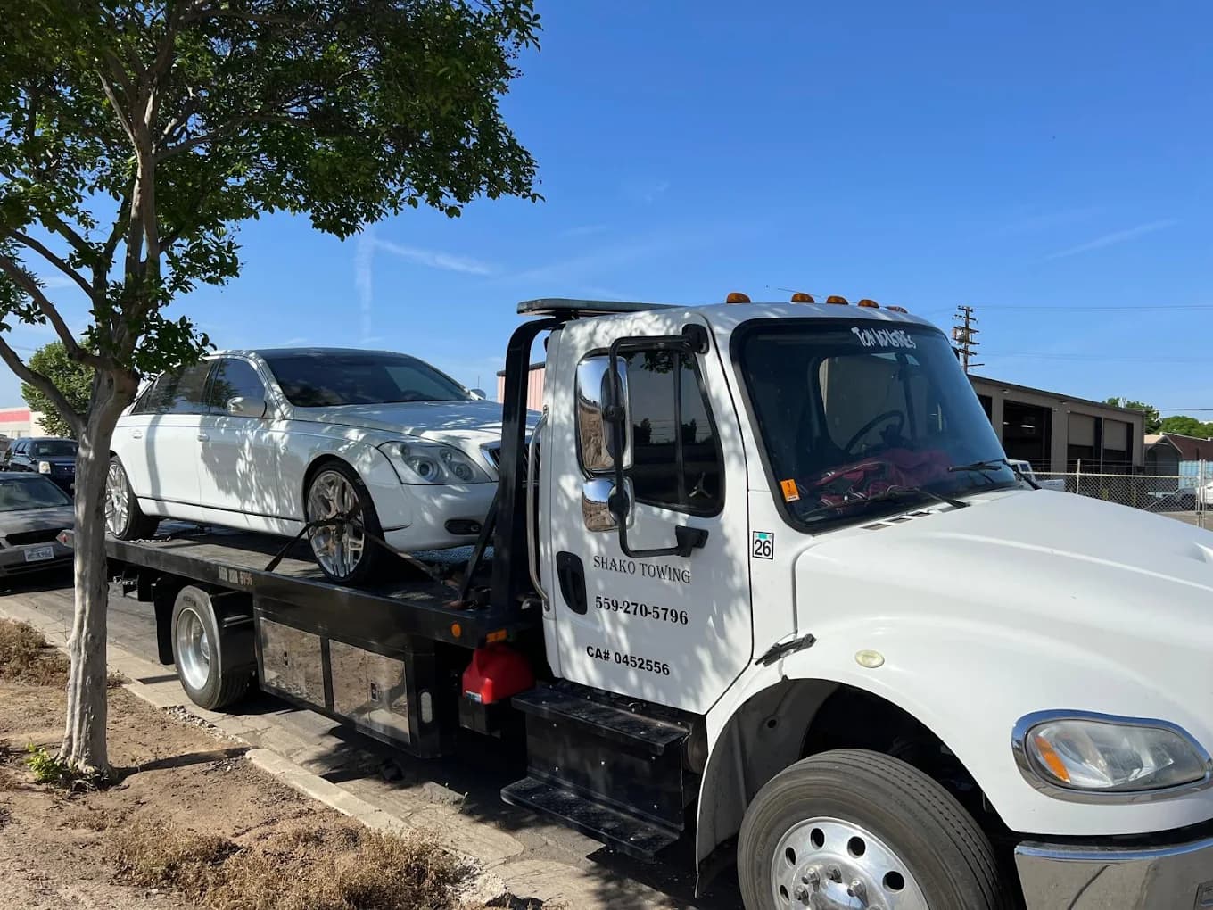 Shako Towing flatbed carrying a white sedan